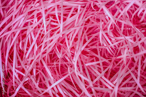 Mess from the deep pink shredded paper strips. Close up.
