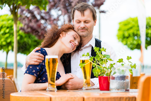 Happy couple in love cuddling in beer garden