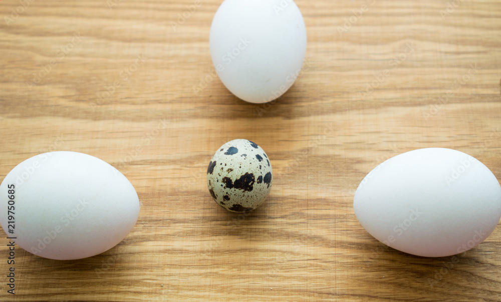 Quail eggs and chicken eggs on a wooden background. Quail eggs and chicken eggs on a wooden background.