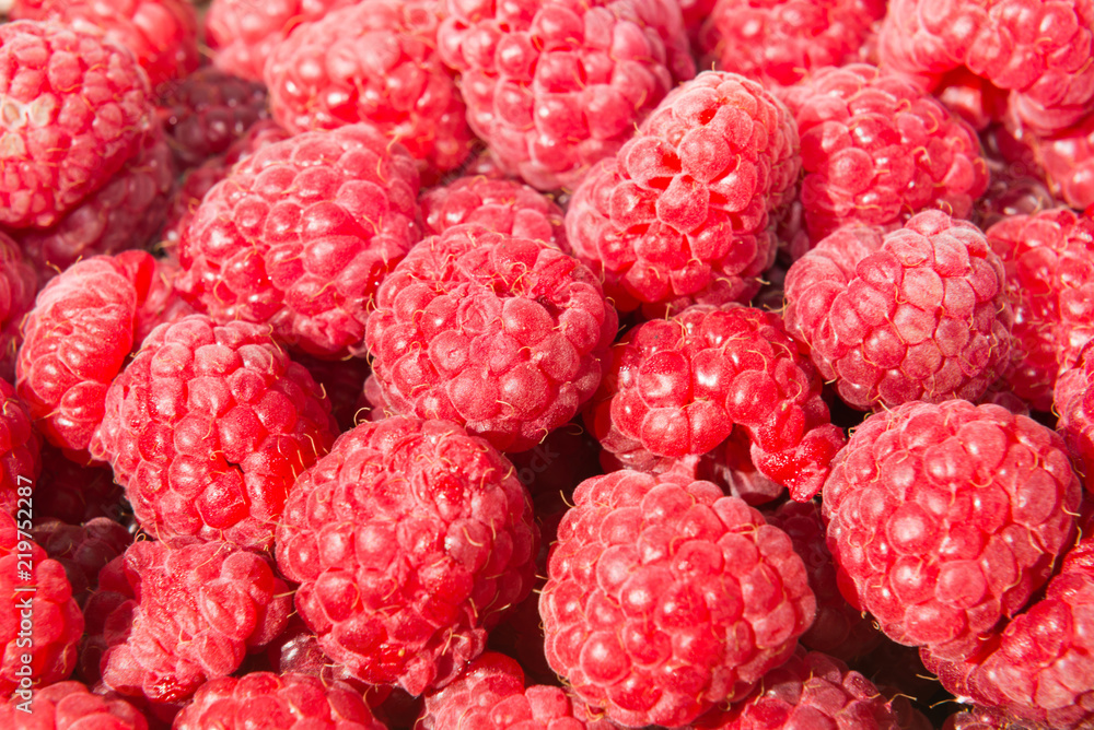 Heap of ripe juicy raspberries in wicker market box Heap of ripe juicy raspberries in wicker market box