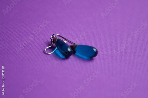 silver earrings with a blue stone on a purple background