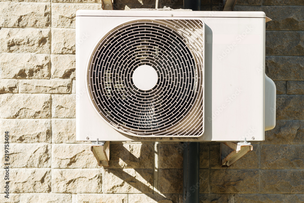 white air conditioner hanging on wall at sunny day white air conditioner hanging on wall at sunny day