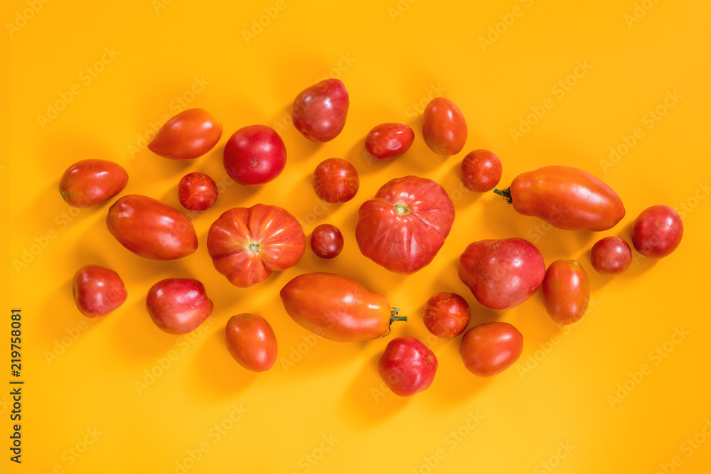 Many different red tomatoes on yellow surface. Many different red tomatoes on yellow surface.