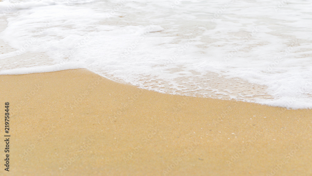 Soft wave foam on sandy beach