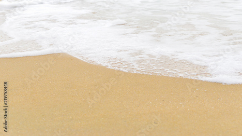 Soft wave foam on sandy beach