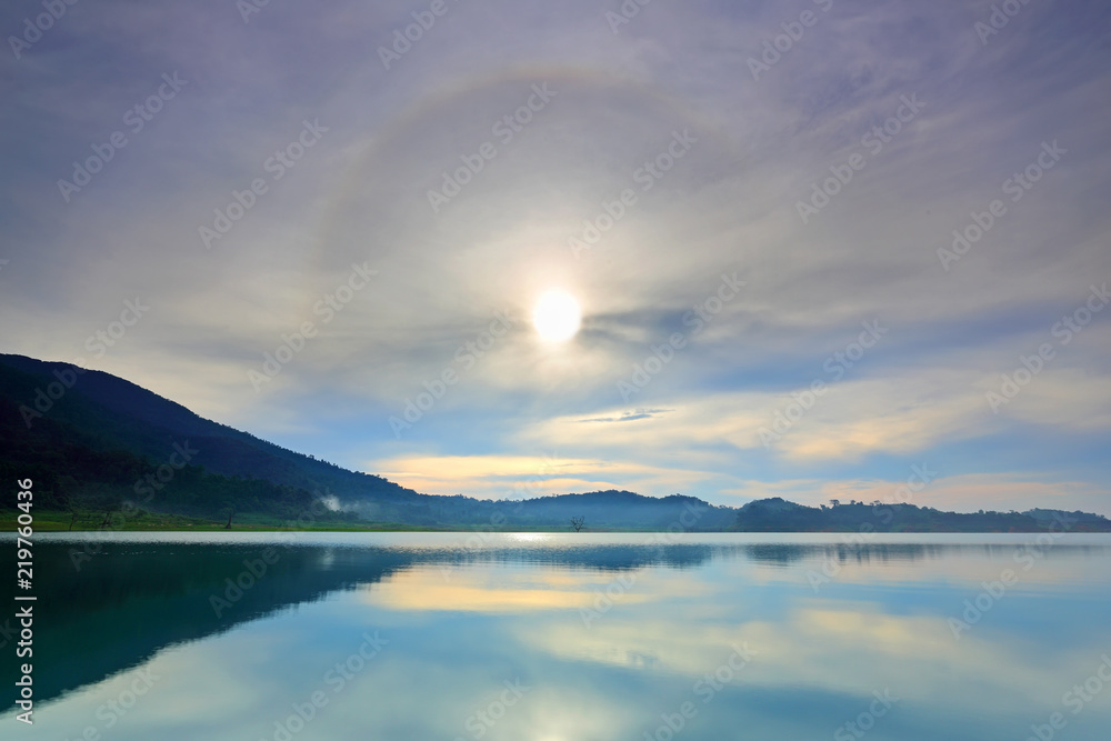 Amazing sun halo above water with lake and mountains