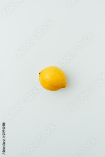 top view of one yellow lemon, on grey