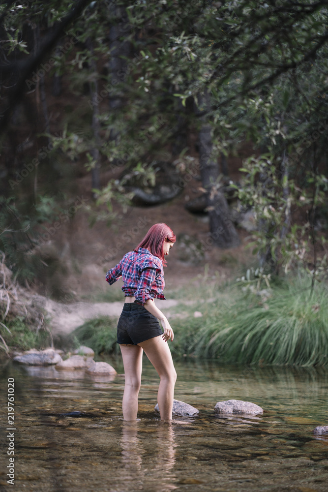 Pretty red haired girl walking along the river. Pretty red haired girl walking along the river.