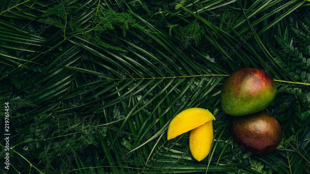 Top view of sweet organic mangos on palm leaves with copy space Top view of sweet organic mangos on palm leaves with copy space