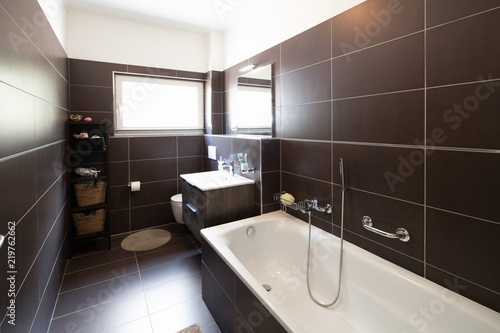 Modern bathroom with brown tiles and window