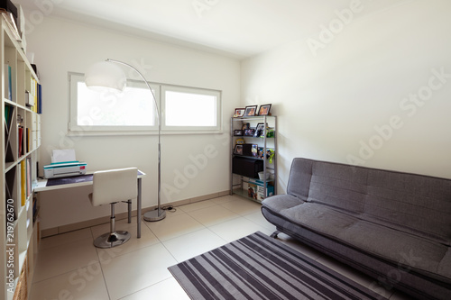 Study room with white walls  sofa and desk