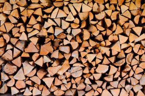 Firewood wooden logs big chopped trunks stacked pile dry for winter fireplace texture background