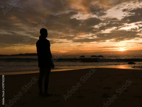 Lonely girl on the sunset beach