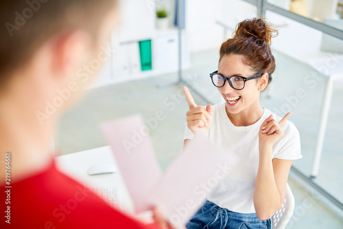 Young businesswoman expressing her excitement about idea to have some fun after work with colleague
