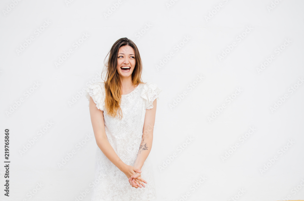 Portrait of beautiful smiling woman in white dress looking at camera Portrait of beautiful smiling woman in white dress looking at camera
