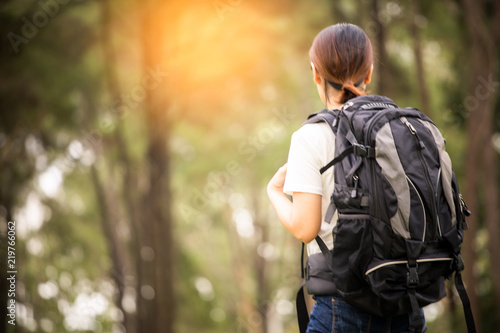 Wallpaper Mural Traveling woman with backpack In the beautiful pine forest at sunset. Torontodigital.ca