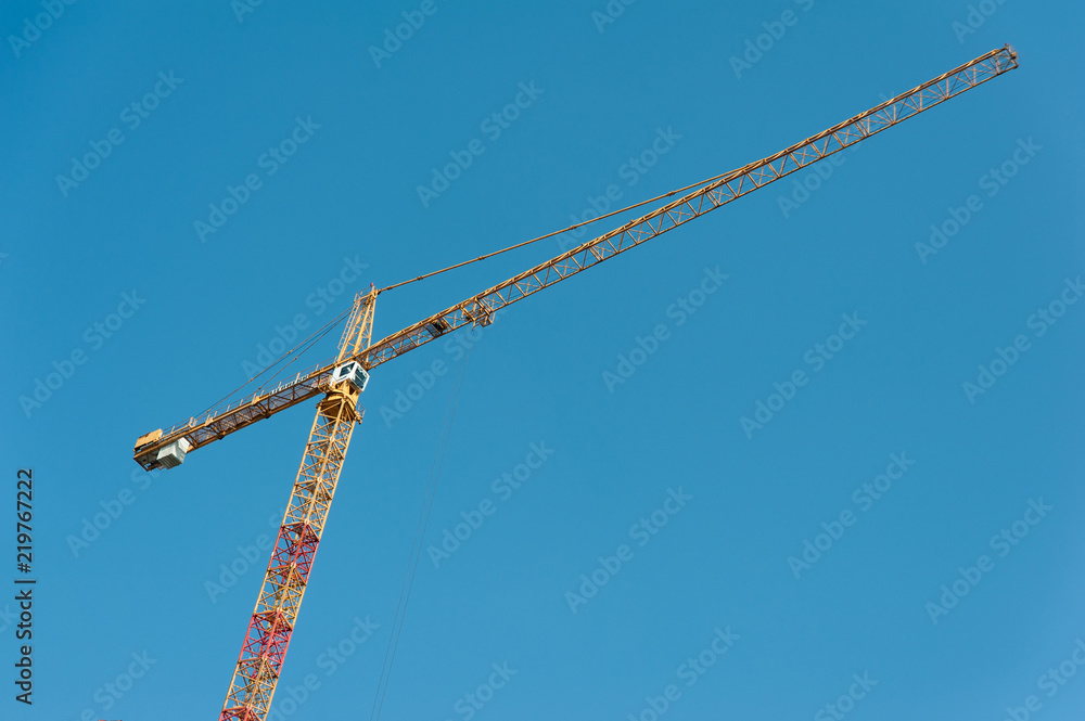 Construction crane on a blue sky background. Construction crane on a blue sky background.