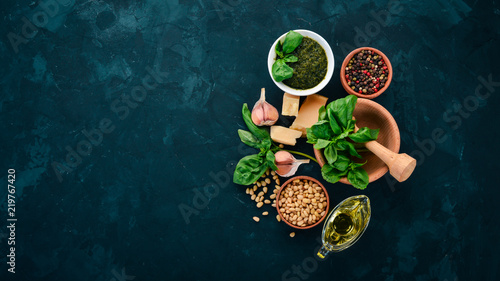 Traditional basil pesto sauce. Basil, parmesan cheese, olive oil, pine nuts, pepper, garlic. Top view. On the stone table. Free space for text.