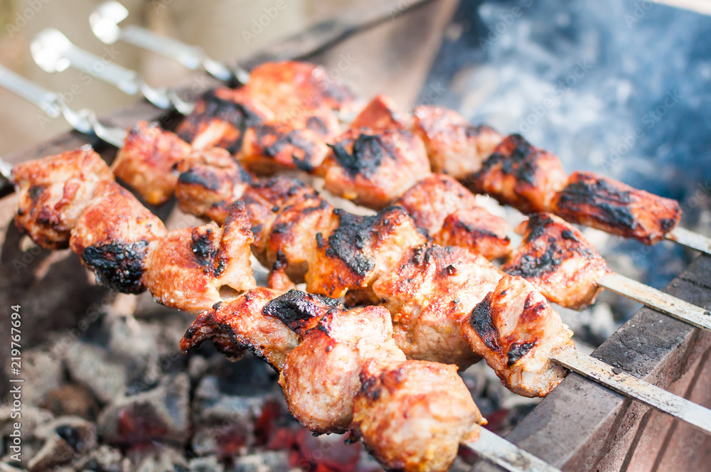 Grilled meat on skewers in the forest Grilled meat on skewers in the forest