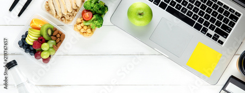Healthy food in meal box set on working table with laptop