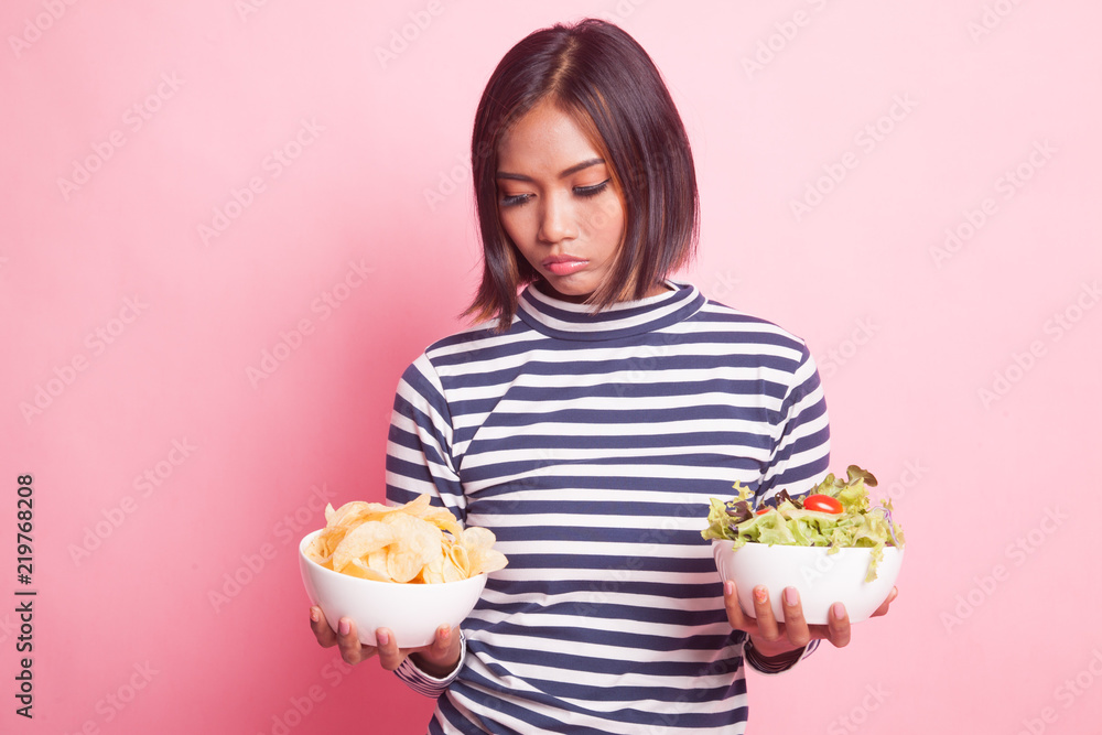 Young Asian woman with potato chips and salad. Young Asian woman with potato chips and salad.