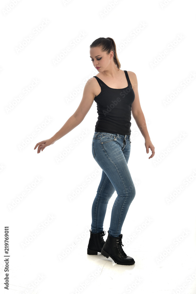 full length portrait of brunette girl wearing black single and jeans. standing pose facing the camera. isolated on white studio background. full length portrait of brunette girl wearing black single and jeans. standing pose facing the camera. isolated on white studio background.