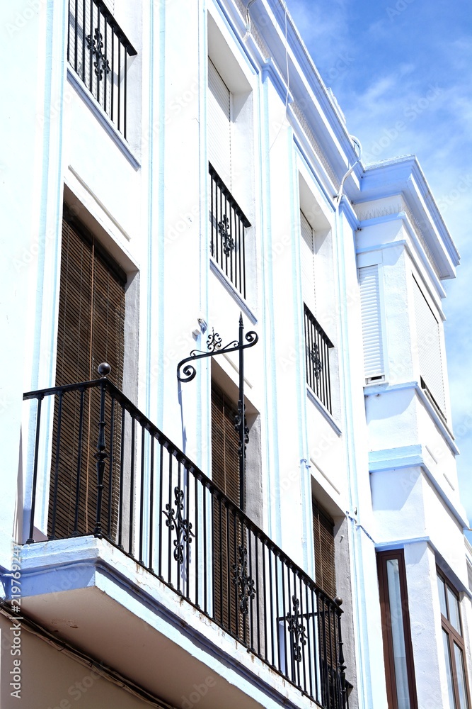 Traditional Spanish buildings with wrought iron balconies along Calle Angustias, Ayamonte, Spain.
