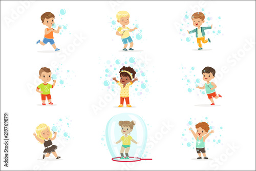 Cute little girls and boys blowing and playing soap bubbles