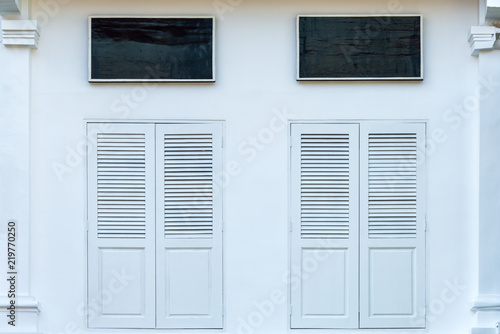 Colorful antique white wooden window Colonial style architecture building with blank black board on white cement wall vintage style in Singapore
