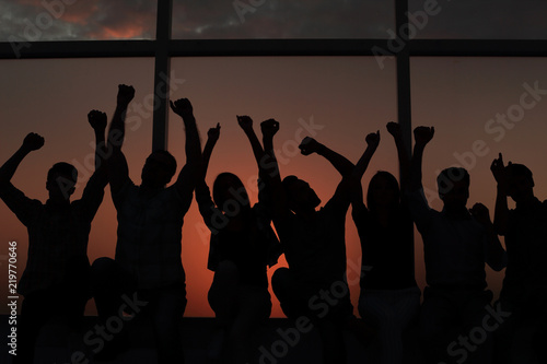 group of positive young people sitting on a windowsill.