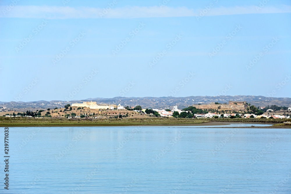 View across the River Guadiana towards the white town and its fort and castle, Castro Marim, Algarve, Portugal.