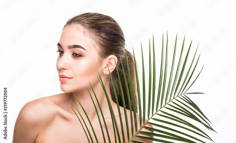 Fototapeta premium Beautiful young woman with palm leaves on white background. Skin care concept.