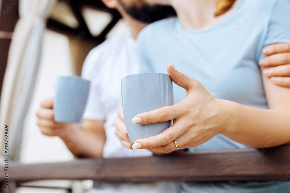 Wedding ring. Blonde-haired woman wearing nice wedding ring drinking coffee with her caring husband Wedding ring. Blonde-haired woman wearing nice wedding ring drinking coffee with her caring husband