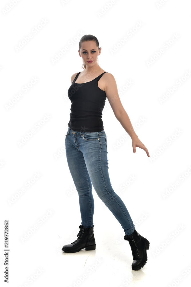 full length portrait of brunette girl wearing black single and jeans. standing pose facing the camera. isolated on white studio background. full length portrait of brunette girl wearing black single and jeans. standing pose facing the camera. isolated on white studio background.