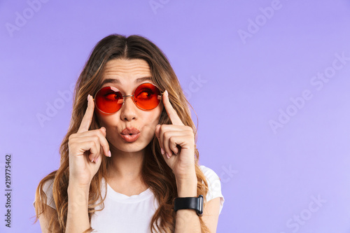 Woman isolated over purple wall background looking aside.
