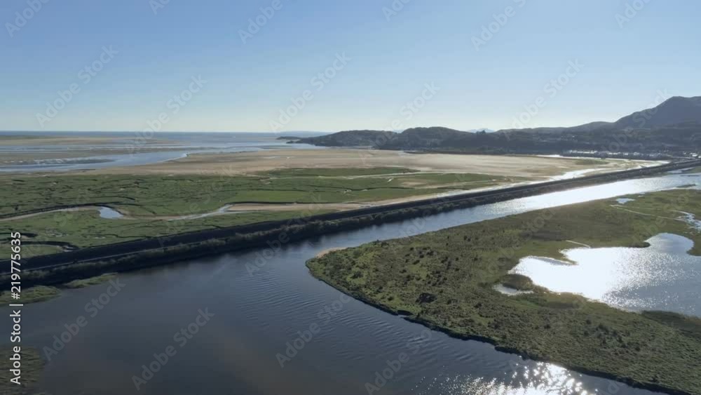 Aerial view, pan move. Drone panorama over Glaslyn wetlands, bridge and Pothmadog in background in North Wales Aerial view, pan move. Drone panorama over Glaslyn wetlands, bridge and Pothmadog in background in North Wales