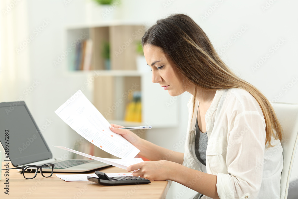 Woman doing accounting comparing documents Woman doing accounting comparing documents