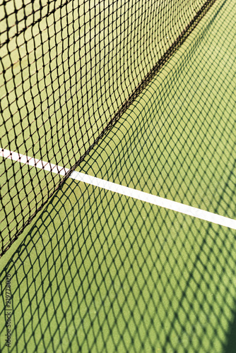 close up view of net with shadow on green tennis court © LIGHTFIELD STUDIOS