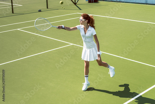 young female tennis player in sunglasses playing tennis on court © LIGHTFIELD STUDIOS