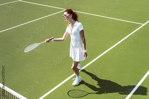 beautiful woman on white sportswear and sunglasses playing tennis on court © LIGHTFIELD STUDIOS