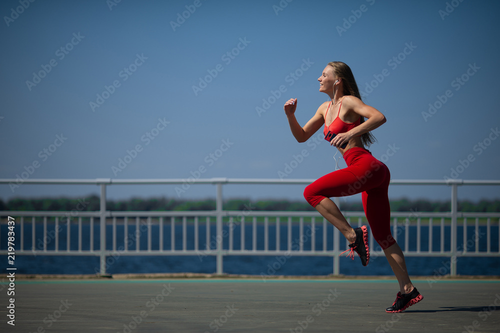 Young fitness woman running on the coast. The concept of a healthy lifestyle Young fitness woman running on the coast. The concept of a healthy lifestyle