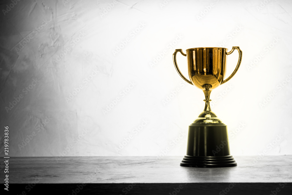 champion golden trophy placed on wooden table champion golden trophy placed on wooden table