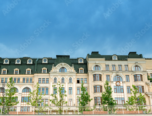 front of modern buildings townhouse with terrace benches and trees at closed living territory