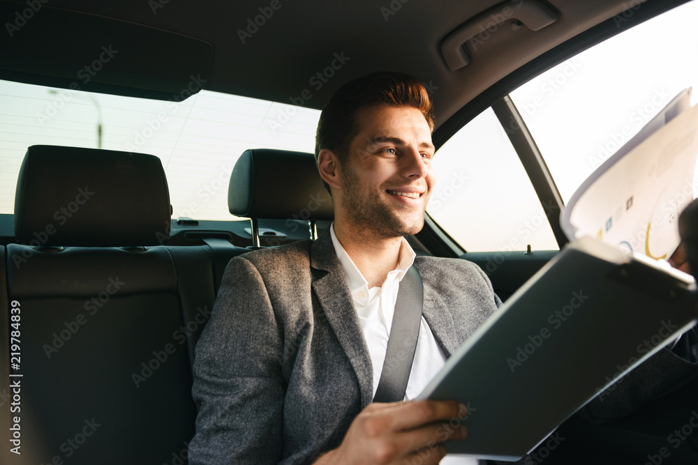 Smiling businessman looking through documents