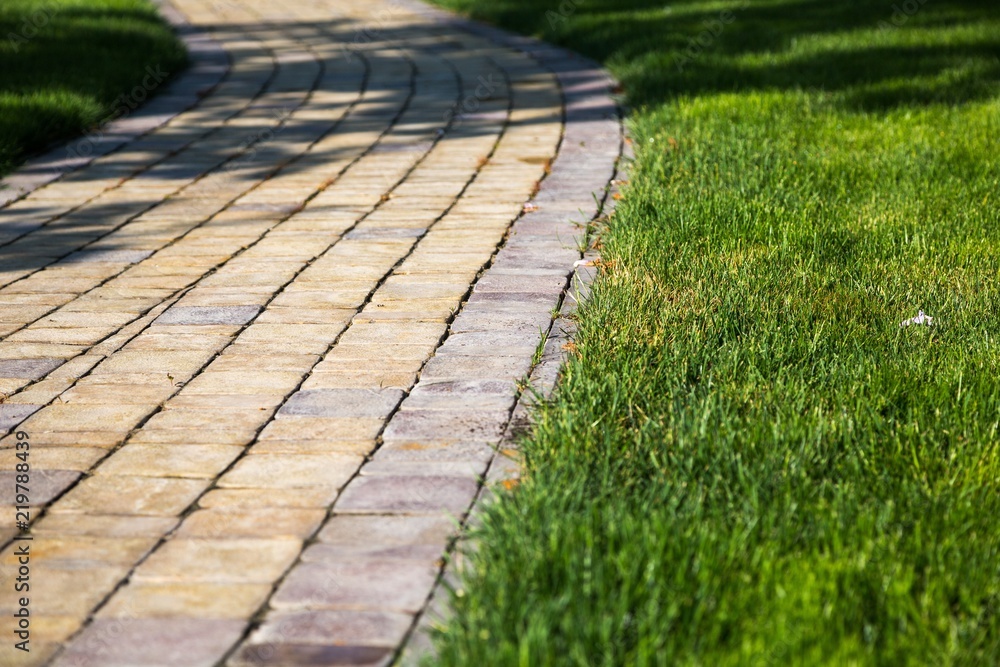 Sidewalk made from pavers running through a lawn Sidewalk made from pavers running through a lawn