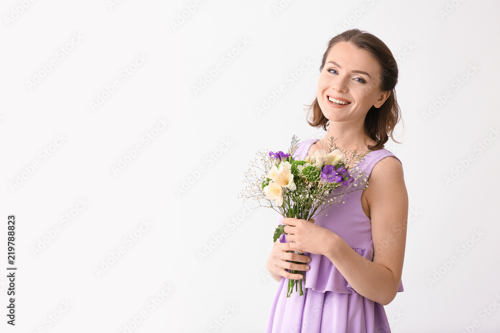Beautiful woman with bouquet of flowers on light background Beautiful woman with bouquet of flowers on light background