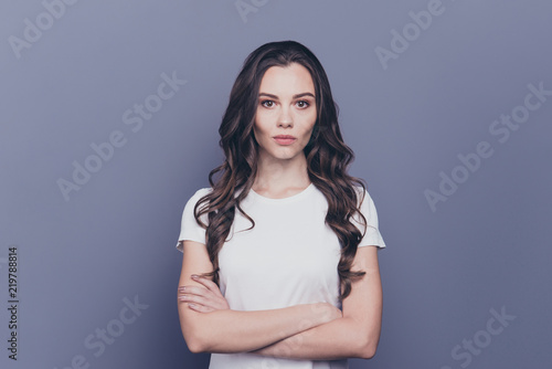 Attractive pretty adorable minded stylish curly-haired girl in white t-shirt, folded arms, isolated over grey background