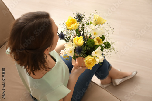 Woman with bouquet of beautiful flowers at home