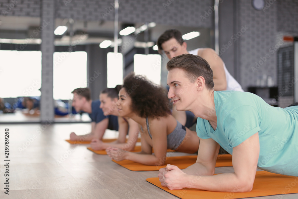 Sporty young people doing exercise in gym Sporty young people doing exercise in gym