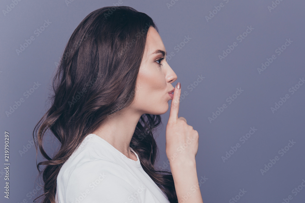 Close-up profile side view portrait of magnificent lovely adorable gorgeous stylish nice funny curly-haired girl in casual white t-shirt, showing shhh gesture, isolated over grey background Close-up profile side view portrait of magnificent lovely adorable gorgeous stylish nice funny curly-haired girl in casual white t-shirt, showing shhh gesture, isolated over grey background